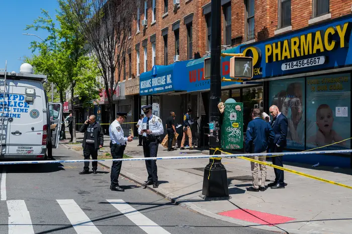 NYPD detectives in Queens investigate the scene of a fatal shooting in May.
